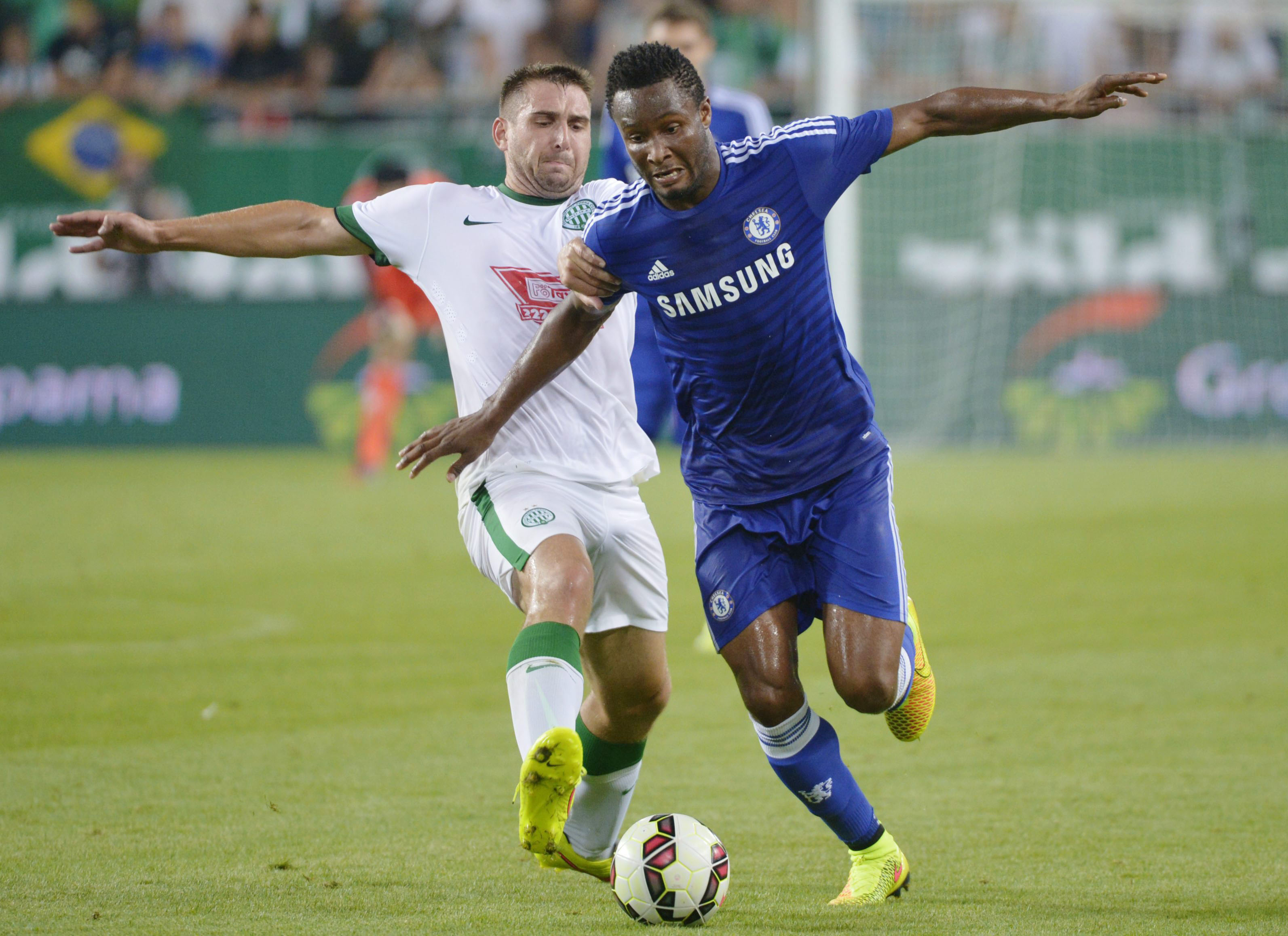 epa04349074 Daniel Boede of Ferencvaros (L) and John Obi Mikel of Chelsea fight for the ball during their friendly soccer match played after the inauguration ceremony of the Groupama Arena, the new stadium of Ferencvaros in Budapest, Hungary 10 August 2014. EPA/LASZLO BELICZAY HUNGARY OUT