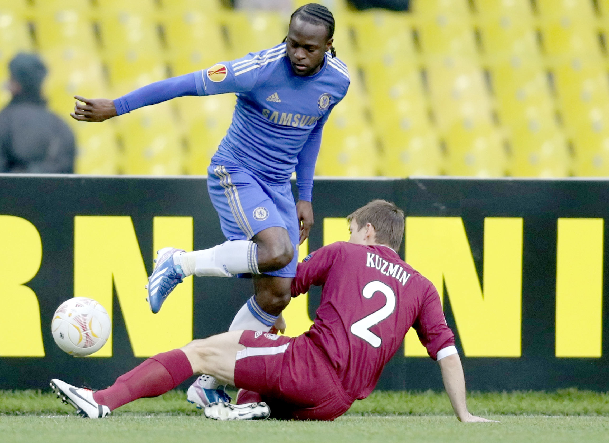 epa03658197 Oleg Kuzmin (bottom) of Rubin Kazan vies for the ball with Victor Moses (top) of Chelsea during the UEFA Europa League quarter-final second leg match between Rubin Kazan and Chelsea at Luzhniki stadium in Moscow, Russia, 11 April 2013.  EPA/MAXIM SHIPENKOV
