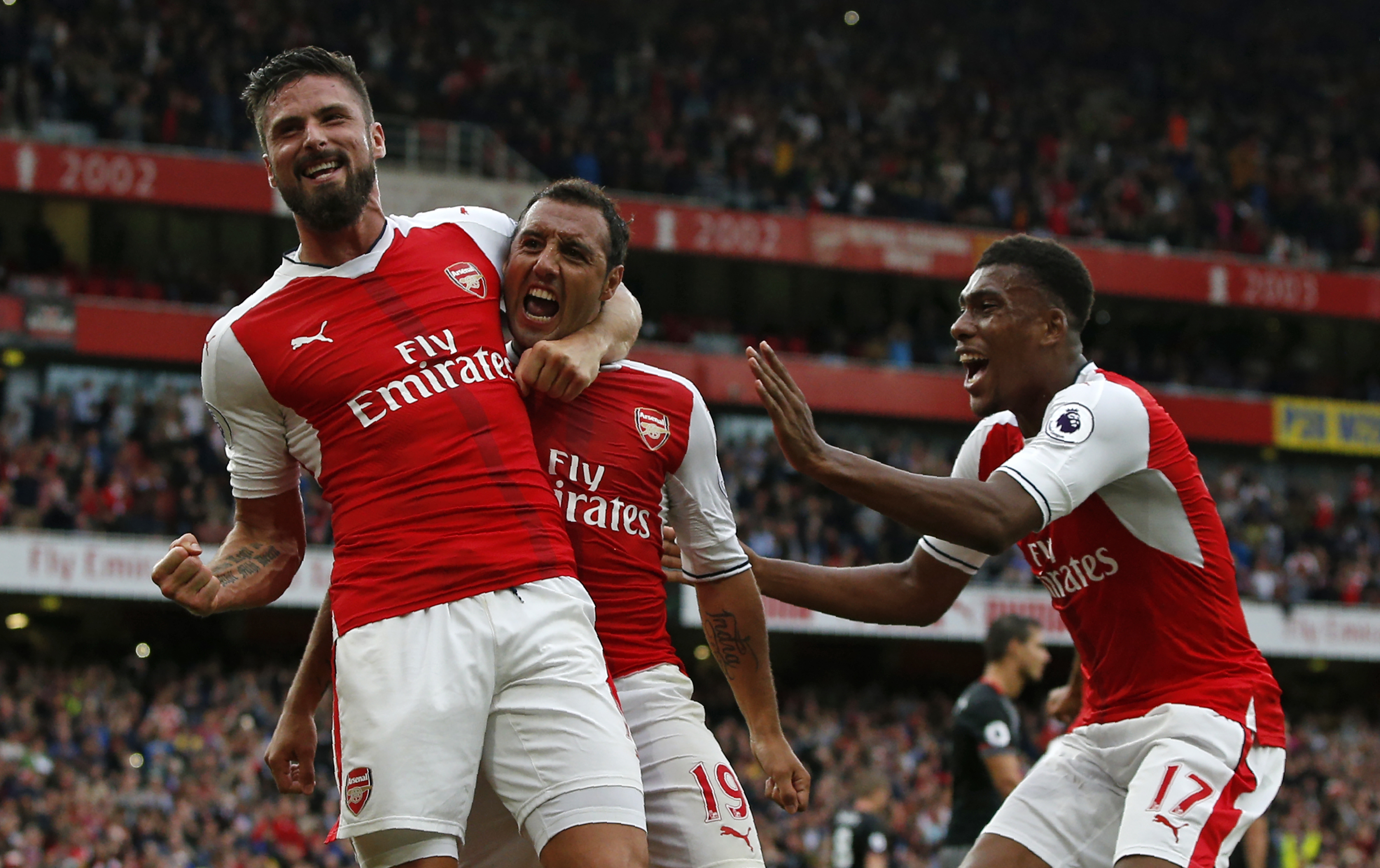 Arsenal's Spanish midfielder Santi Cazorla (C) celebrates with Arsenal's French striker Olivier Giroud and Arsenal's Nigerian striker Alex Iwobi (R) after scoring the winning goal from the penalty spot during the English Premier League football match between Arsenal and Southampton at the Emirates Stadium in London on September 10, 2016. 
Arsenal won the game 2-1. / AFP / Adrian DENNIS / RESTRICTED TO EDITORIAL USE. No use with unauthorized audio, video, data, fixture lists, club/league logos or 'live' services. Online in-match use limited to 75 images, no video emulation. No use in betting, games or single club/league/player publications.  /         (Photo credit should read ADRIAN DENNIS/AFP/Getty Images)