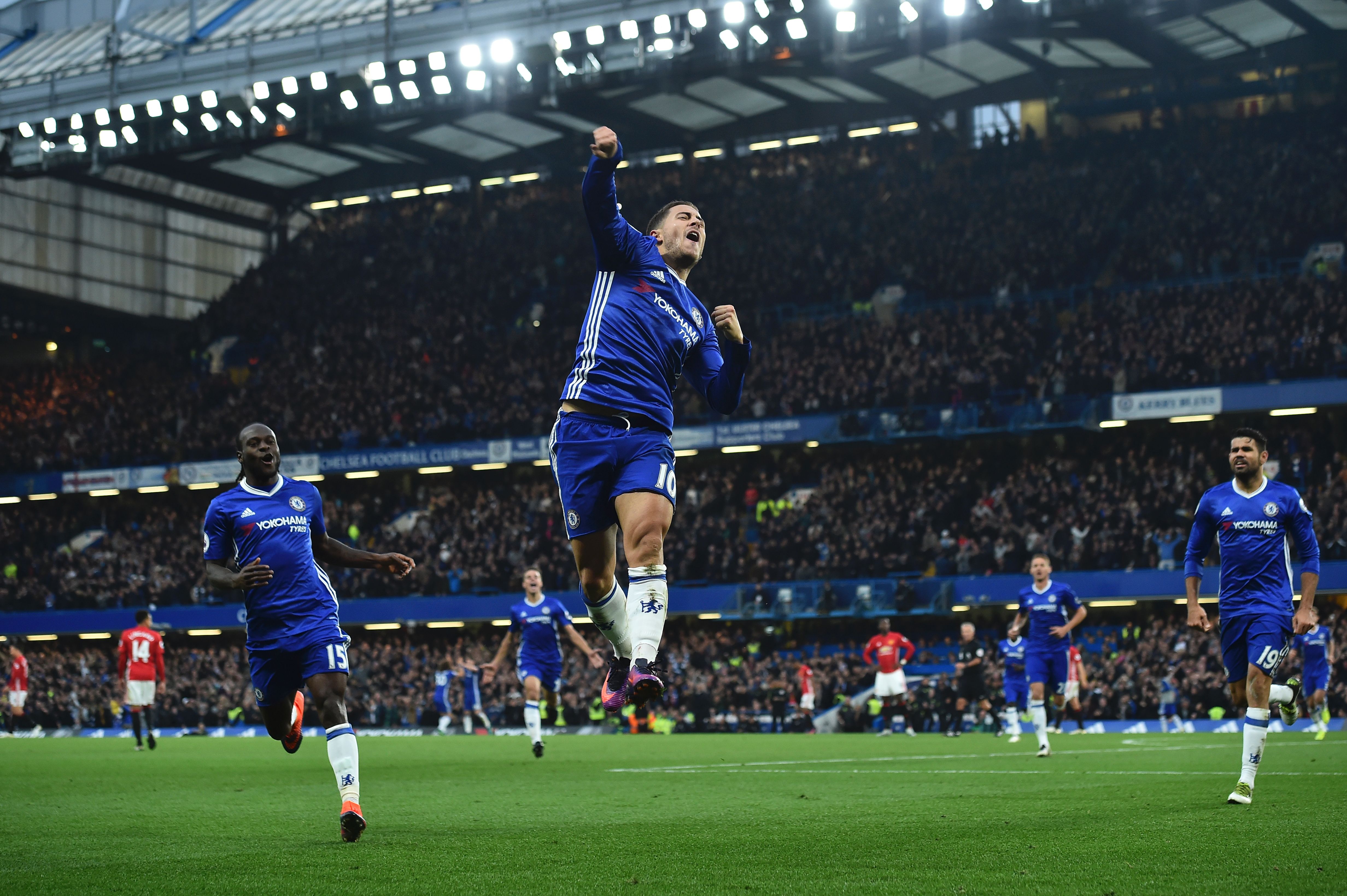 Chelsea's Belgian midfielder Eden Hazard (C) celebrates after scoring their third goal during the English Premier League football match between Chelsea and Manchester United at Stamford Bridge in London on October 23, 2016. / AFP / Glyn KIRK / RESTRICTED TO EDITORIAL USE. No use with unauthorized audio, video, data, fixture lists, club/league logos or 'live' services. Online in-match use limited to 75 images, no video emulation. No use in betting, games or single club/league/player publications.  /         (Photo credit should read GLYN KIRK/AFP/Getty Images)