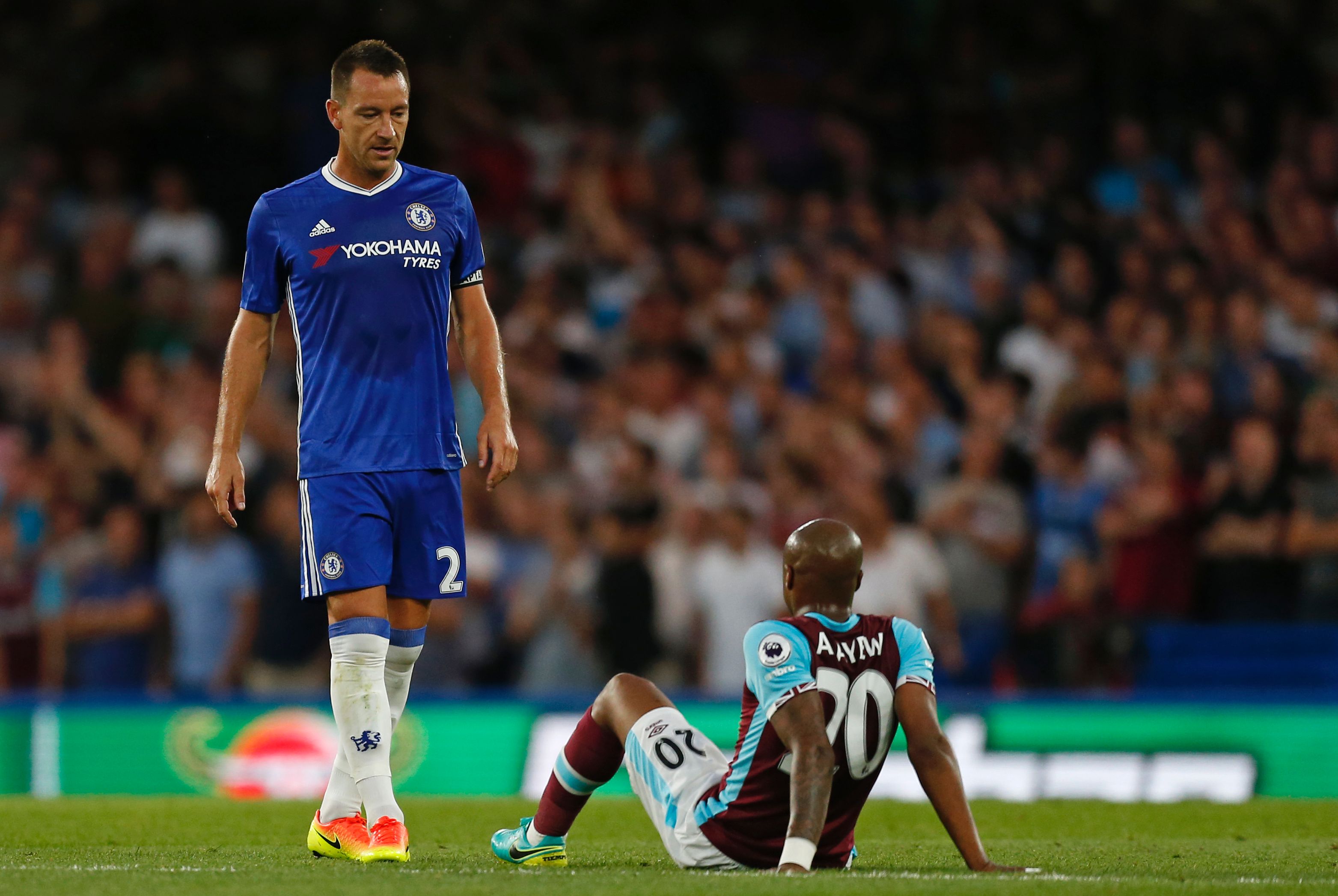 Chelsea's English defender John Terry (L) walks past an injured West Ham United's French-born Ghanaian midfielder Andre Ayew during the English Premier League football match between Chelsea and West Ham United at Stamford Bridge in London on August 15, 2016. / AFP / Ian KINGTON / RESTRICTED TO EDITORIAL USE. No use with unauthorized audio, video, data, fixture lists, club/league logos or 'live' services. Online in-match use limited to 75 images, no video emulation. No use in betting, games or single club/league/player publications.  /         (Photo credit should read IAN KINGTON/AFP/Getty Images)