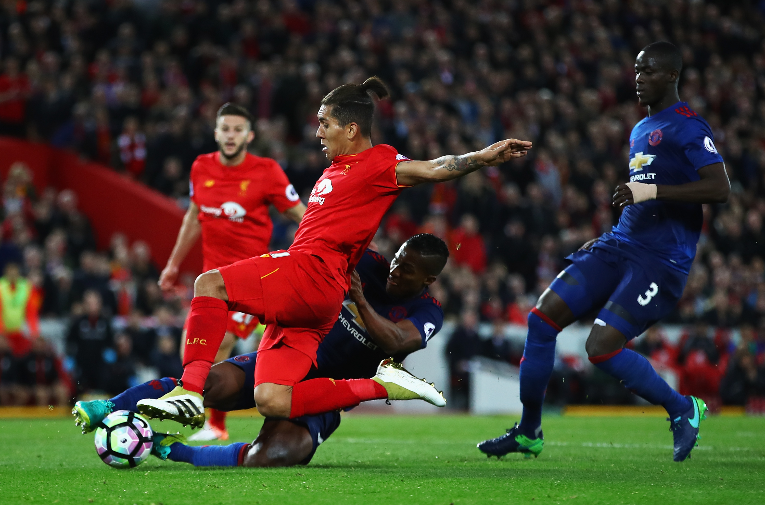 LIVERPOOL, ENGLAND - OCTOBER 17: Antonio Valencia of Manchester United tackles Roberto Firmino of Liverpool during the Premier League match between Liverpool and Manchester United at Anfield on October 17, 2016 in Liverpool, England.  (Photo by Clive Brunskill/Getty Images)