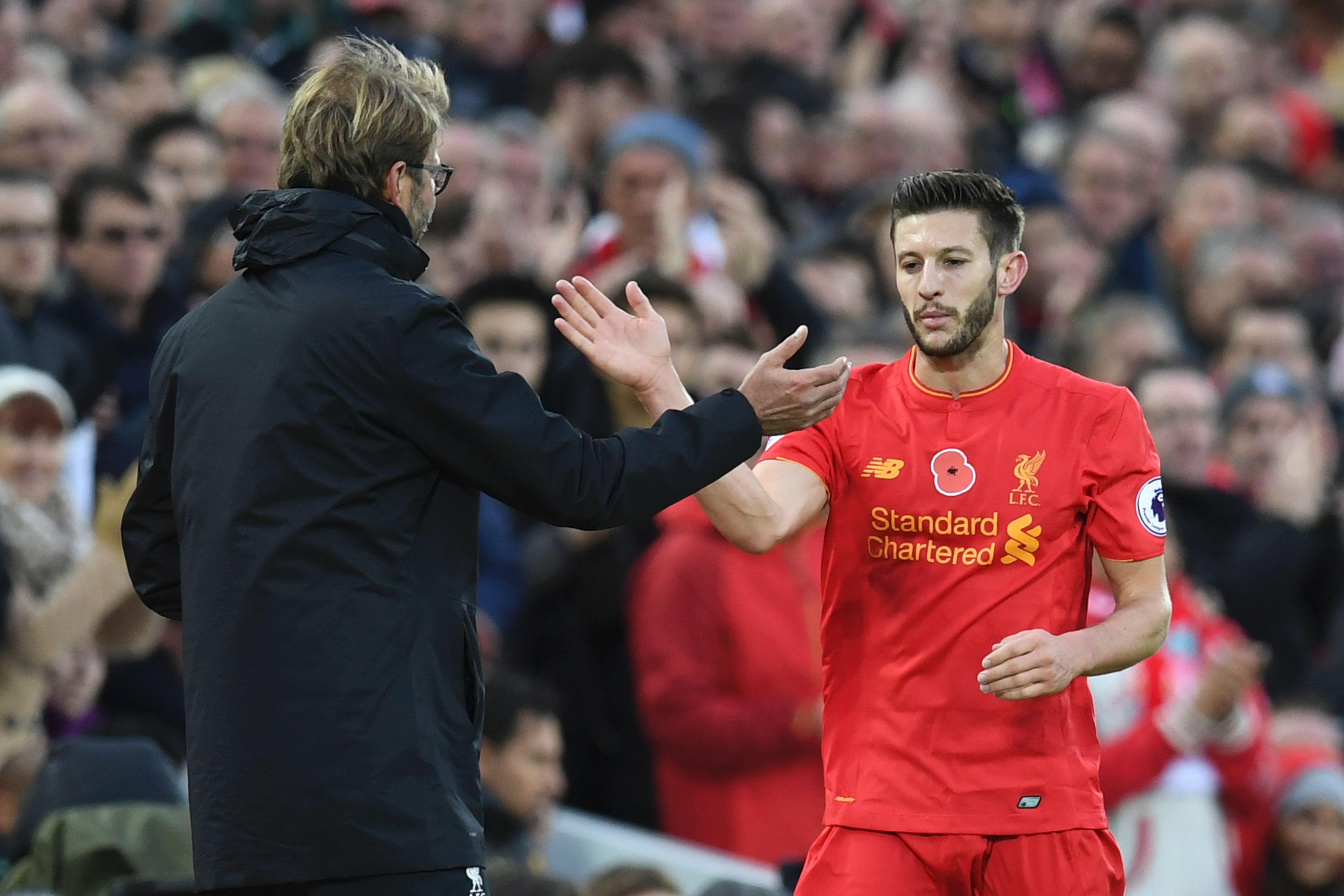 Liverpool's English midfielder Adam Lallana is congratulated by Liverpool's German manager Jurgen Klopp as he is substituted off of the pitch during the English Premier League football match between Liverpool and Watford at Anfield in Liverpool, north west England on November 6, 2016. / AFP / PAUL ELLIS / RESTRICTED TO EDITORIAL USE. No use with unauthorized audio, video, data, fixture lists, club/league logos or 'live' services. Online in-match use limited to 75 images, no video emulation. No use in betting, games or single club/league/player publications. / (Photo credit should read PAUL ELLIS/AFP/Getty Images)