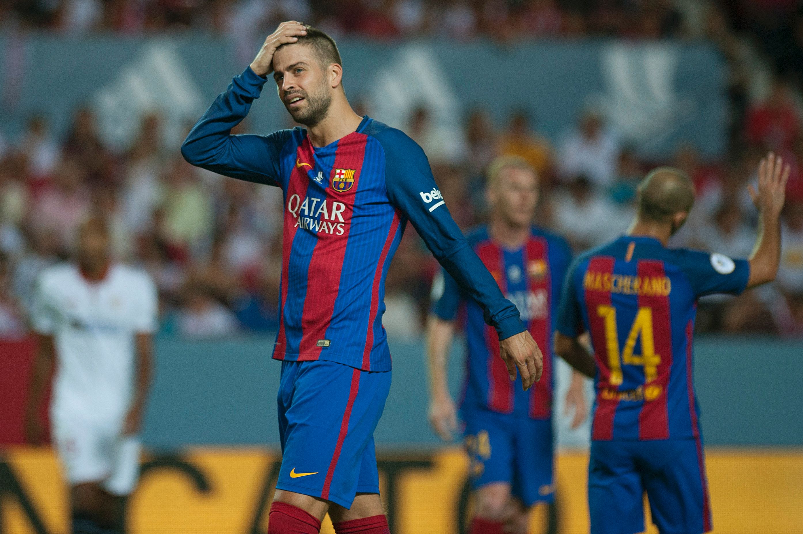 Barcelona's defender Gerard Pique reacts during the first leg of the Spanish Supercup football match between Sevilla FC and FC Barcelona at the Ramon Sanchez Pizjuan stadium in Sevilla on August 14, 2016. / AFP / JORGE GUERRERO        (Photo credit should read JORGE GUERRERO/AFP/Getty Images)