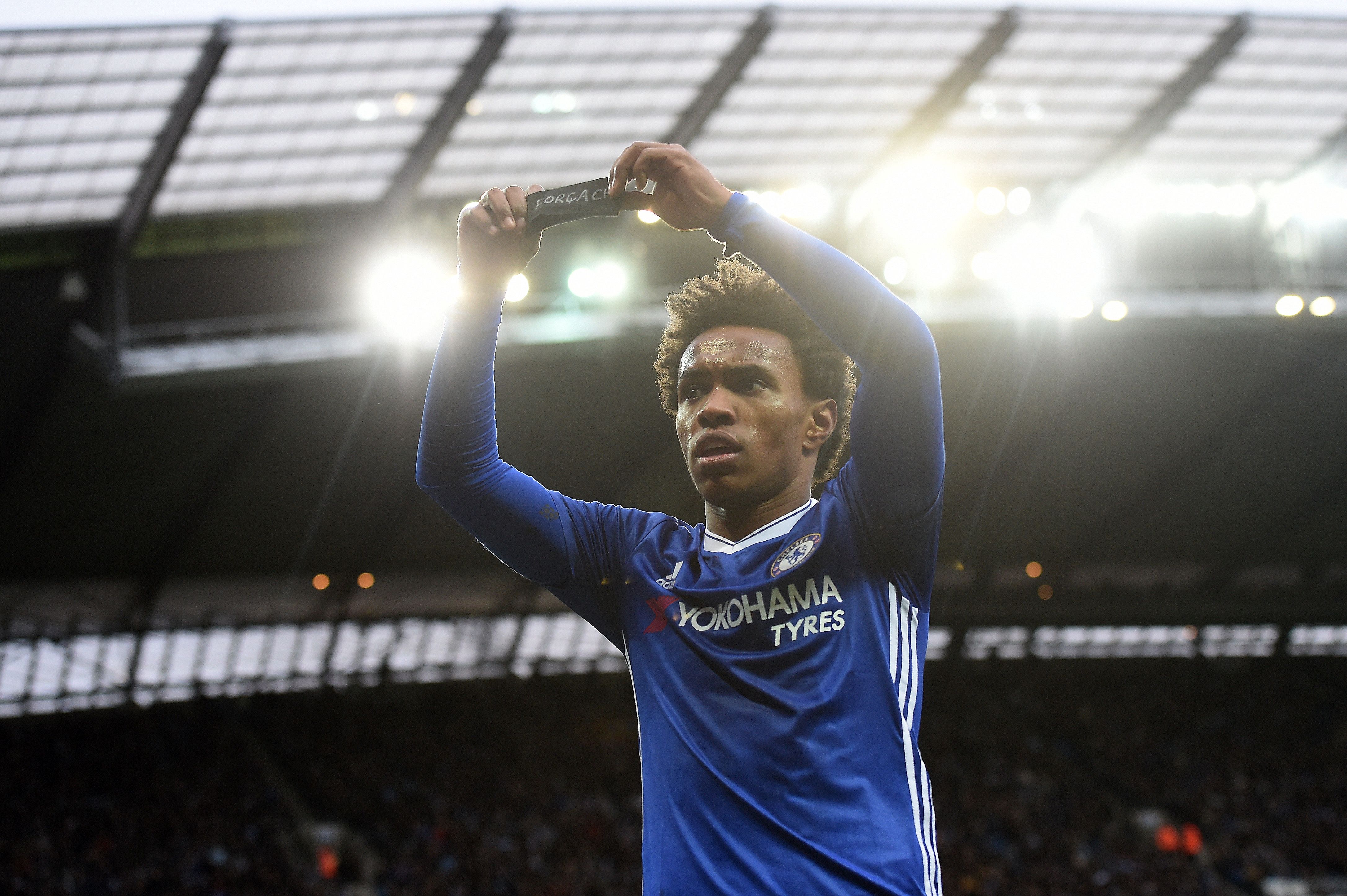 Chelsea's Brazilian midfielder Willian holds up his black armband as he celebrates scoring his team's second goal during the English Premier League football match between Manchester City and Chelsea at the Etihad Stadium in Manchester, north west England, on December 3, 2016. / AFP / Paul ELLIS / RESTRICTED TO EDITORIAL USE. No use with unauthorized audio, video, data, fixture lists, club/league logos or 'live' services. Online in-match use limited to 75 images, no video emulation. No use in betting, games or single club/league/player publications. / (Photo credit should read PAUL ELLIS/AFP/Getty Images)
