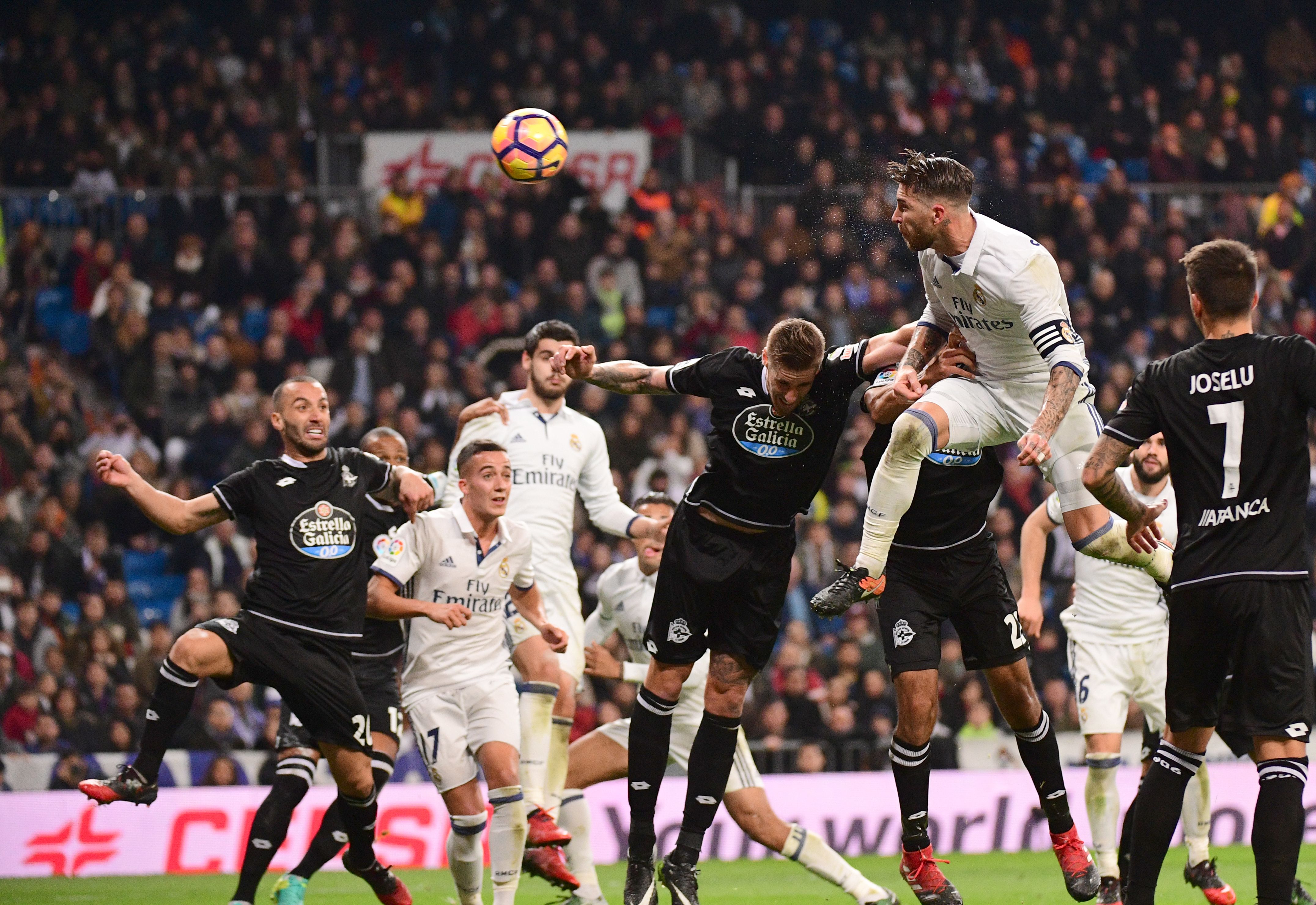 Real Madrid's defender Sergio Ramos (R) heads the ball to score during the Spanish league football match Real Madrid CF vs RC Deportivo at the Santiago Bernabeu stadium in Madrid on December 10, 2016. / AFP / PIERRE-PHILIPPE MARCOU (Photo credit should read PIERRE-PHILIPPE MARCOU/AFP/Getty Images)