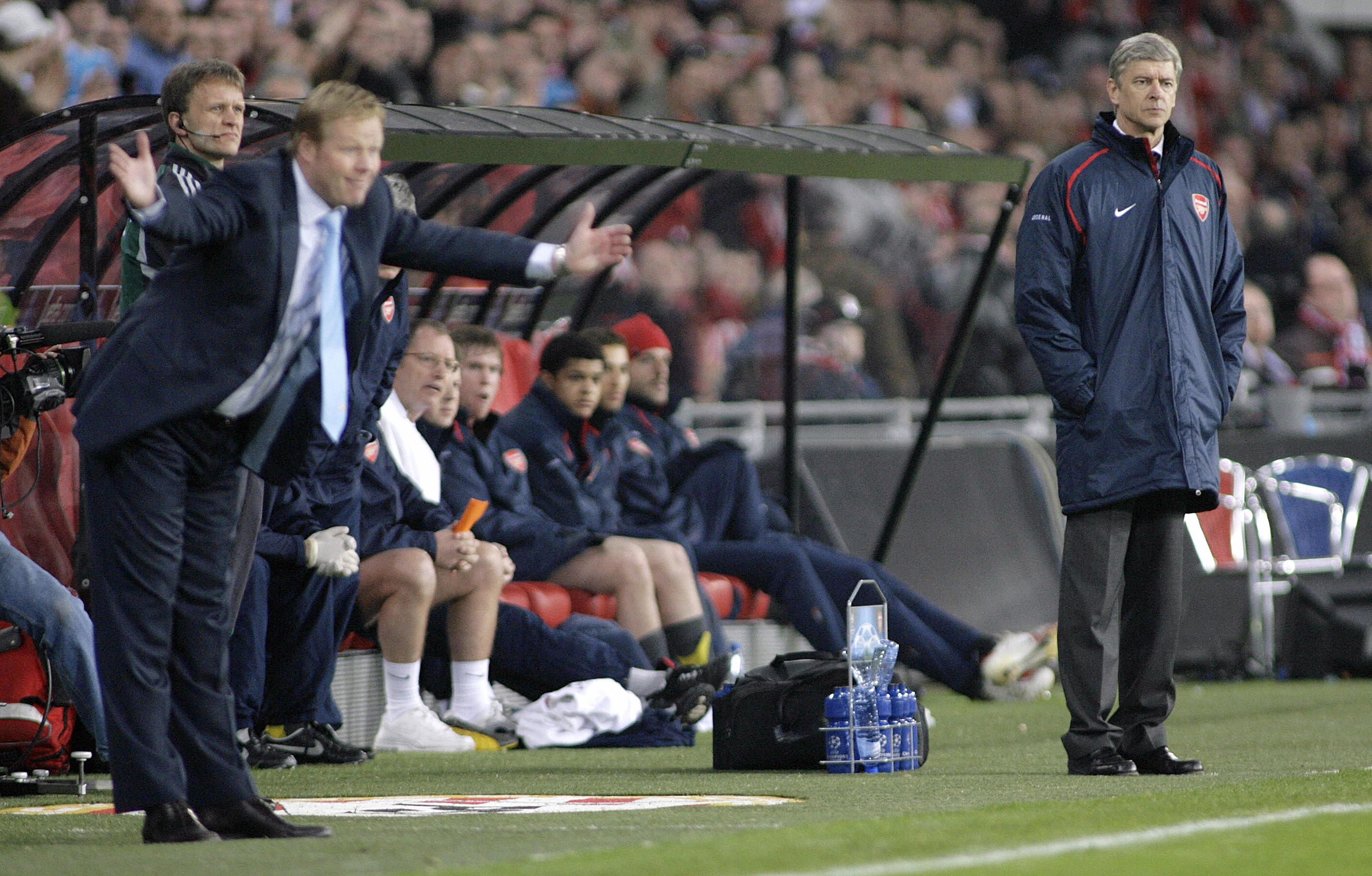 Eindhoven, NETHERLANDS: PSV coach Ronald Koeman (L) and Arsenal's French coach Arsene Wenger (R) watch the Champions League, first knockout round match PSV Eindhoven vs. Arsenal at the Philips Stadium in Eindhoven, 20 February 2007. PSV won 1-0. AFP PHOTO / MAARTJE BLIJDENSTEIN (Photo credit should read MAARTJE BLIDENSTEIN/AFP/Getty Images)