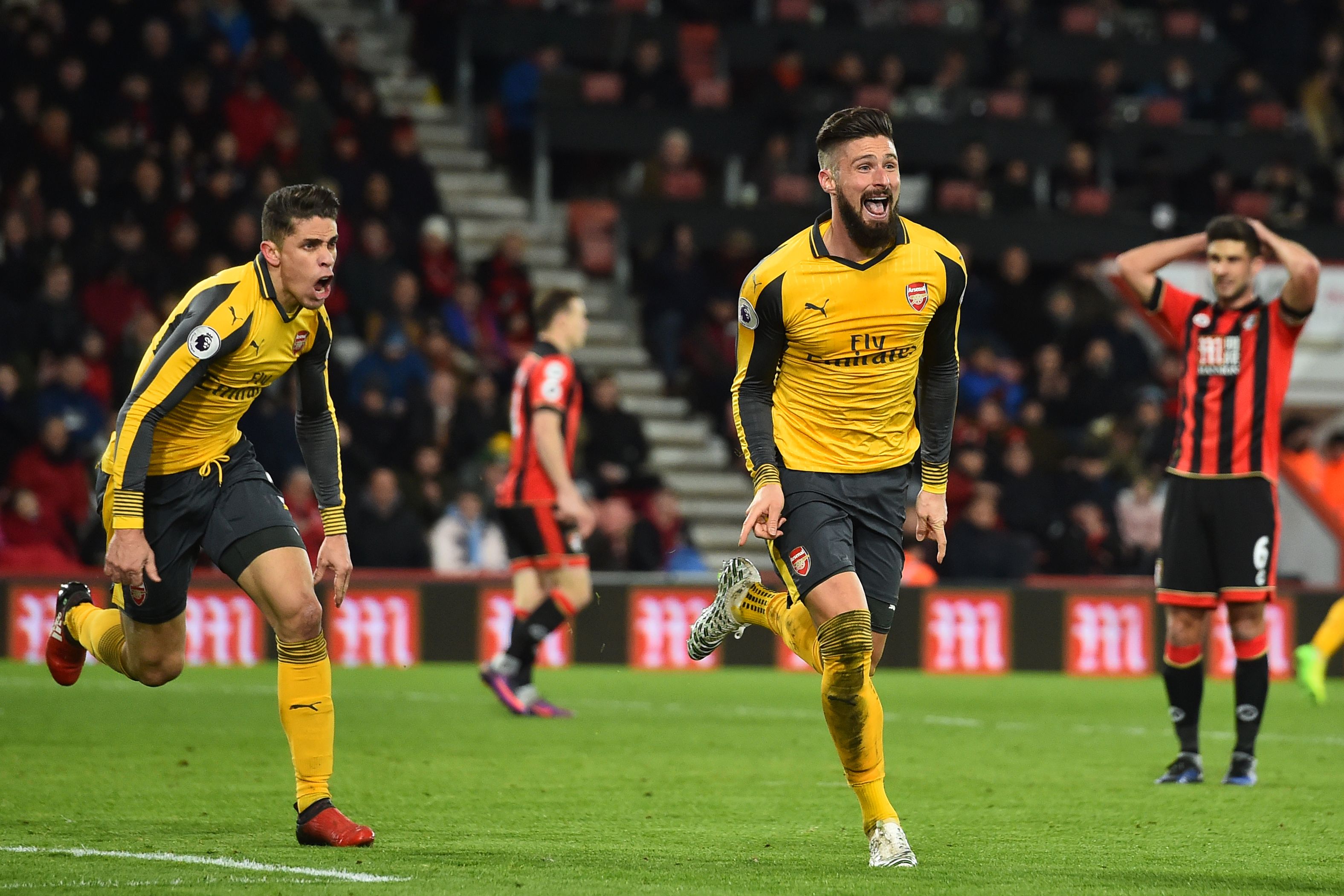 Arsenal's French striker Olivier Giroud (2nd R) and Arsenal's Brazilian defender Gabriel (L) celebrate as Bournemouth's South African-born English midfielder Andrew Surman (R) reacts after Giroud scores their third goal during the English Premier League football match between Bournemouth and Arsenal at the Vitality Stadium in Bournemouth, southern England on January 3, 2017.
The game finished 3-3. / AFP / Glyn KIRK / RESTRICTED TO EDITORIAL USE. No use with unauthorized audio, video, data, fixture lists, club/league logos or 'live' services. Online in-match use limited to 75 images, no video emulation. No use in betting, games or single club/league/player publications. / (Photo credit should read GLYN KIRK/AFP/Getty Images)