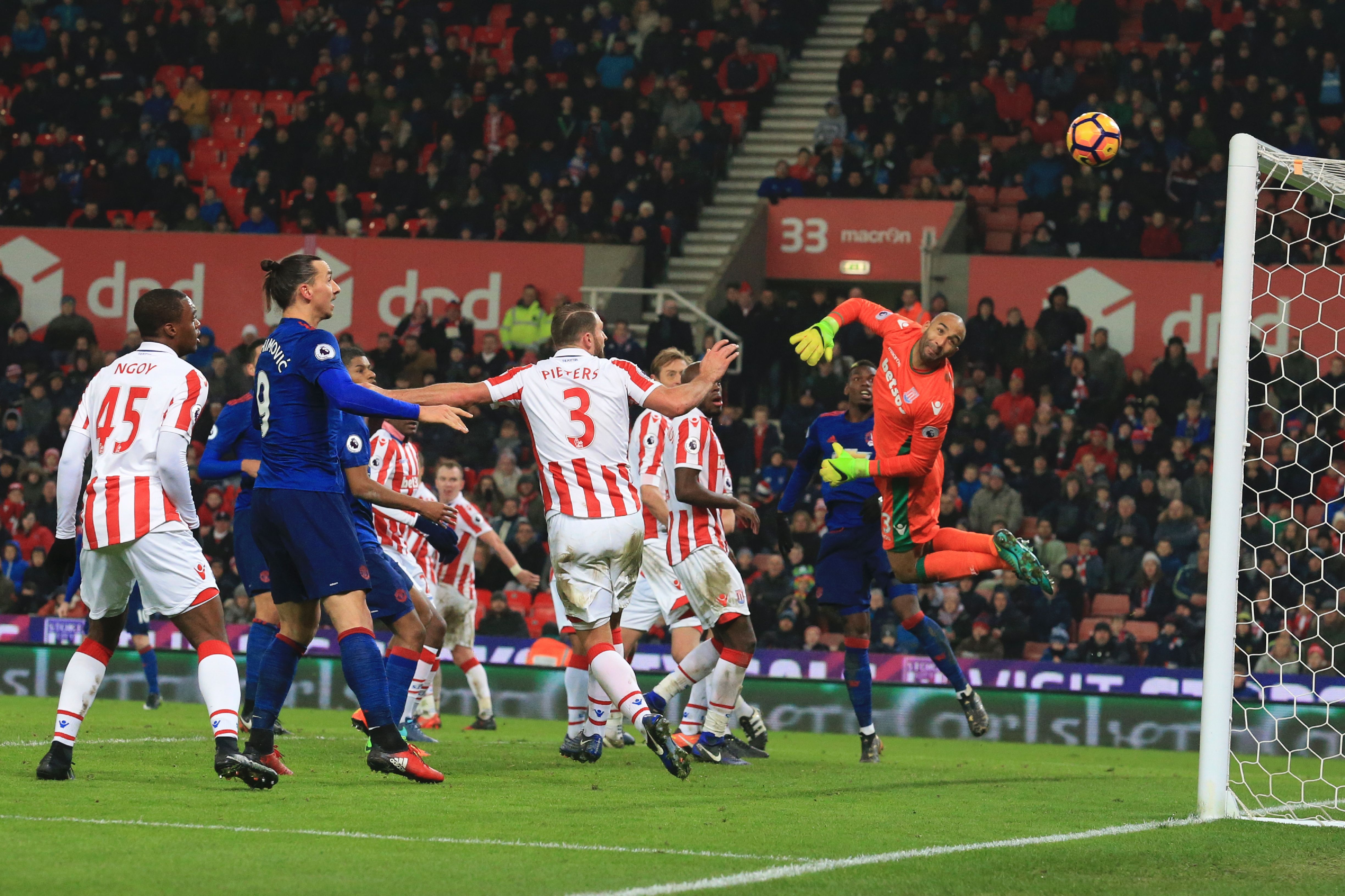 Stoke City's English goalkeeper Lee Grant (R) looks back as he dives to see the ball go into his goal from a free kick hit by Manchester United's English striker Wayne Rooney (L obscured) for Rooney to score an equalising goal for 1-1 and his 250th goal for Manchester United making him the club's all-time record scorer during the English Premier League football match between Stoke City and Manchester United at the Bet365 Stadium in Stoke-on-Trent, central England on January 21, 2017. (Photo by Lindsey Parnaby/AFP/Getty Images)