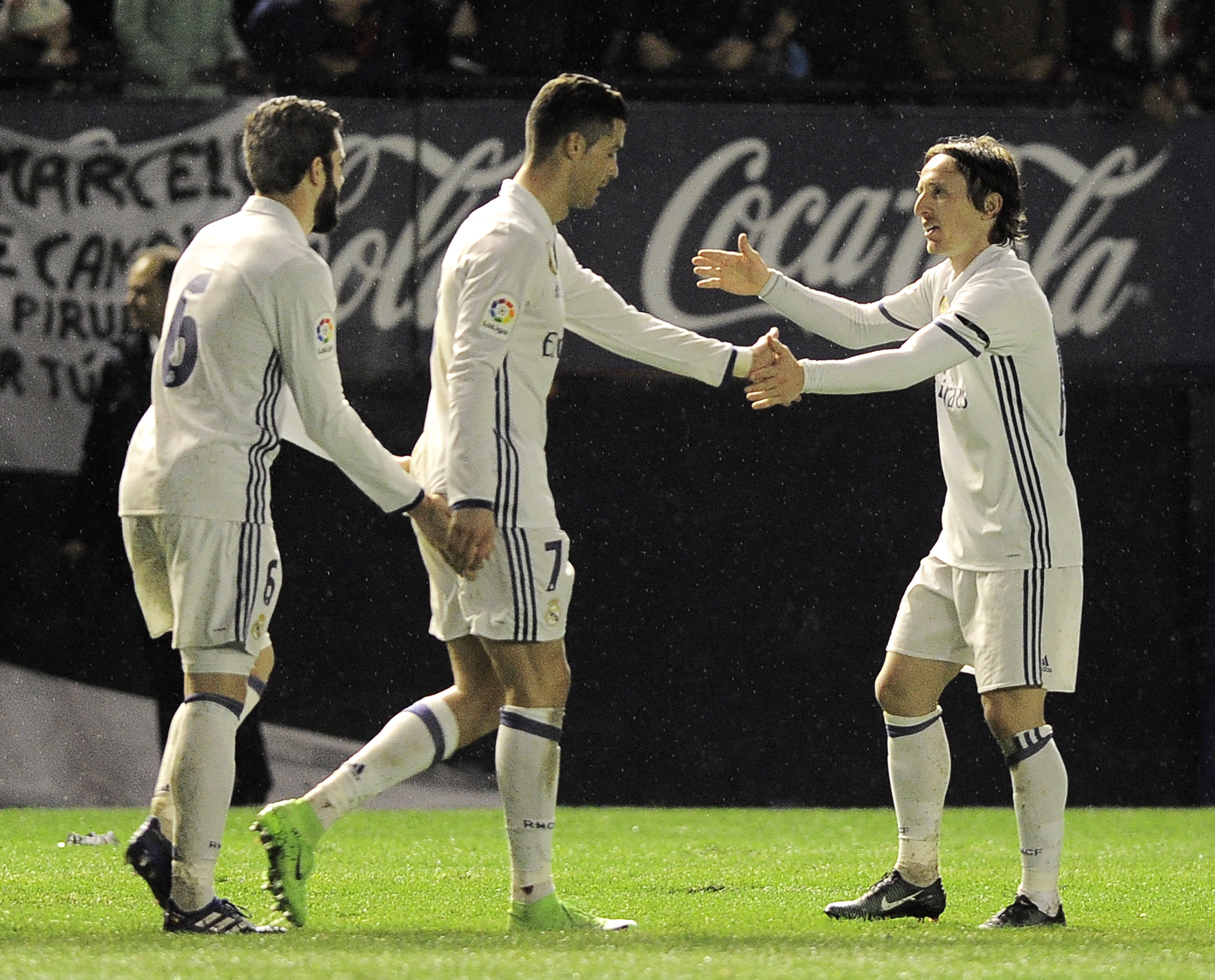 (L-R) Real Madrid's defender Nacho Fernandez, Portuguese forward Cristiano Ronaldo and Croatian midfielder Luka Modric celebrate after forward Lucas Vazquez scoring his team's third goal during the Spanish league football match CA Osasuna vs Real Madrid CF at El Sadar stadium in Pamplona on February 11, 2017. / AFP / ANDER GILLENEA        (Photo credit should read ANDER GILLENEA/AFP/Getty Images)