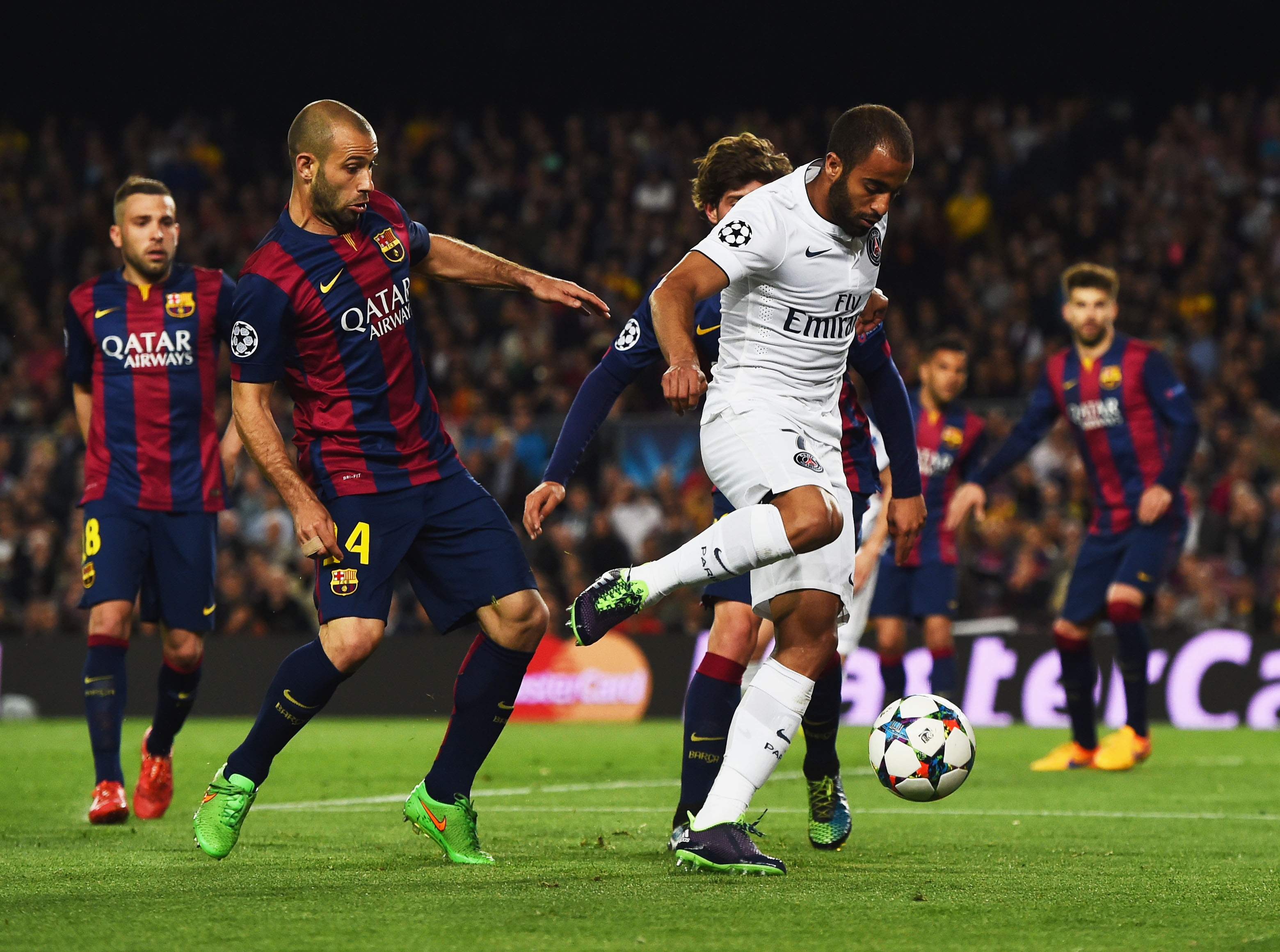 BARCELONA, SPAIN - APRIL 21: Lucas of PSG takes on Javier Mascherano and Sergi Roberto of Barcelona during the UEFA Champions League Quarter Final second leg match between FC Barcelona and Paris Saint-Germain at Camp Nou on April 21, 2015 in Barcelona, Spain. (Photo by David Ramos/Getty Images)