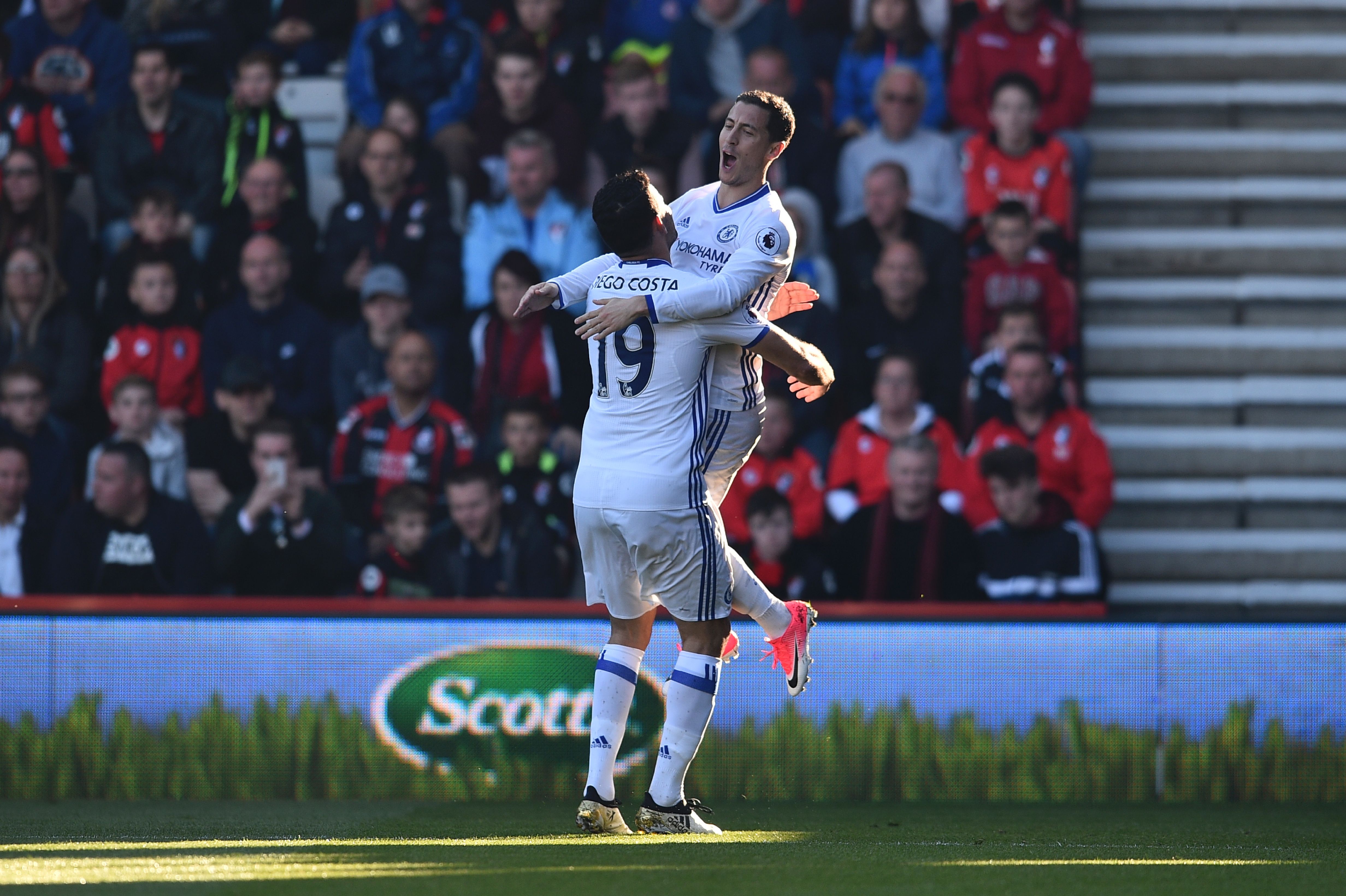 Chelsea's Belgian midfielder Eden Hazard (R) jumps into the arms of Chelsea's Brazilian-born Spanish striker Diego Costa (L) as he celebrates scoring their second goal during the English Premier League football match between Bournemouth and Chelsea at the Vitality Stadium in Bournemouth, southern England on April 8, 2017. / AFP PHOTO / Glyn KIRK / RESTRICTED TO EDITORIAL USE. No use with unauthorized audio, video, data, fixture lists, club/league logos or 'live' services. Online in-match use limited to 75 images, no video emulation. No use in betting, games or single club/league/player publications.  /         (Photo credit should read GLYN KIRK/AFP/Getty Images)