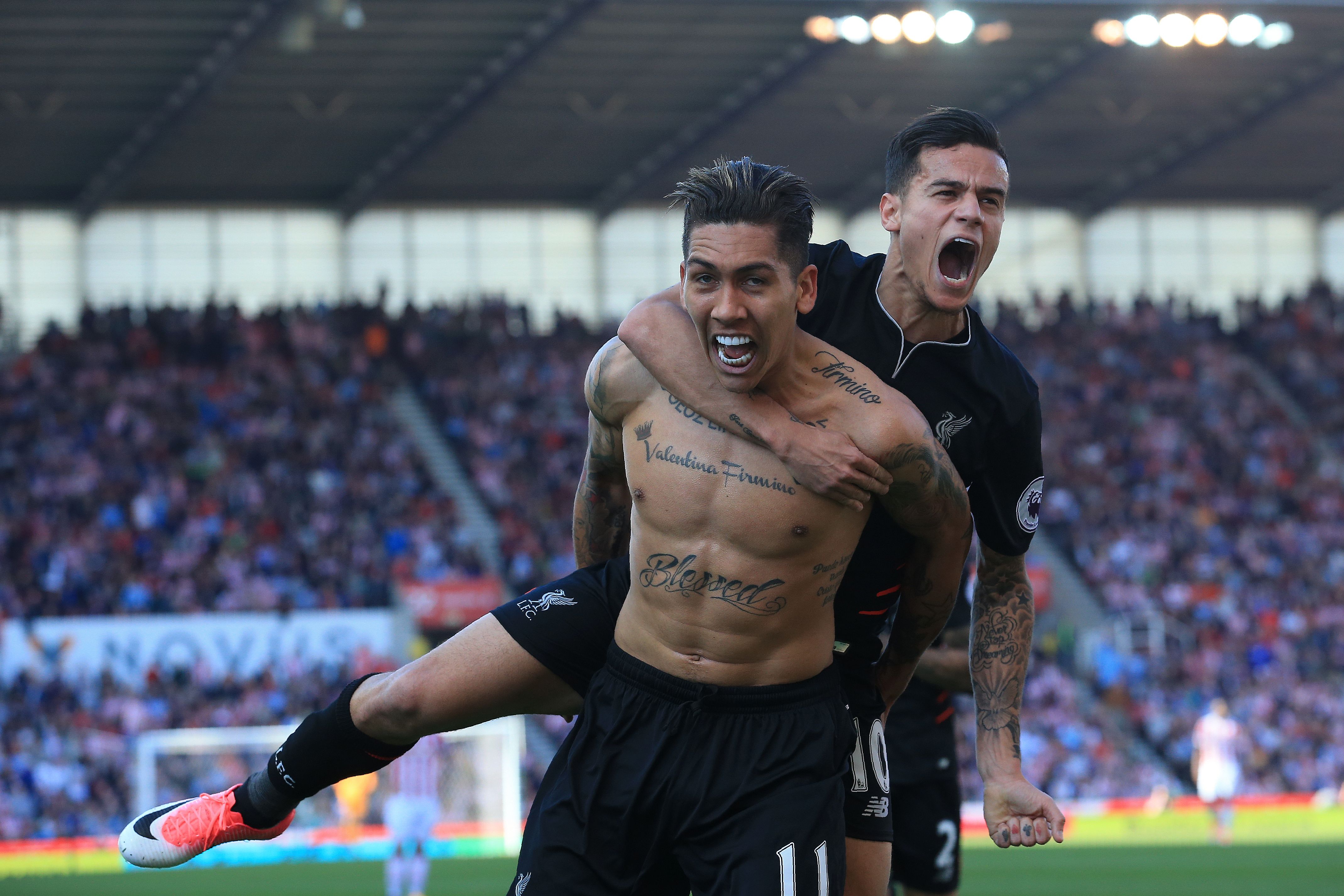 Liverpool's Brazilian midfielder Roberto Firmino (L) celebrates scoring his team's second goal with Liverpool's Brazilian midfielder Philippe Coutinho during the English Premier League football match between Stoke City and Liverpool at the Bet365 Stadium in Stoke-on-Trent, central England on April 8, 2017. / AFP PHOTO / Lindsey PARNABY / RESTRICTED TO EDITORIAL USE. No use with unauthorized audio, video, data, fixture lists, club/league logos or 'live' services. Online in-match use limited to 75 images, no video emulation. No use in betting, games or single club/league/player publications.  /         (Photo credit should read LINDSEY PARNABY/AFP/Getty Images)