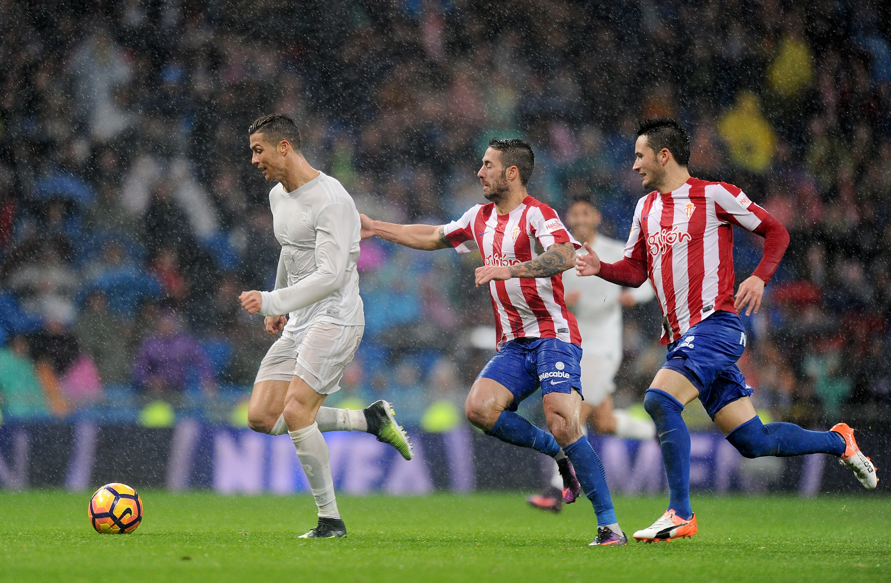 MADRID, SPAIN - NOVEMBER 26: Cristiano Ronaldo of Real Madrid CF is chased by Manuel Castellano 'Lillo' of Real Sporting de Gijon during the La Liga match between Real Madrid CF and Real Sporting de Gijon at Estadio Santiago Bernabeu on November 26, 2016 in Madrid, Spain. (Photo by Denis Doyle/Getty Images)