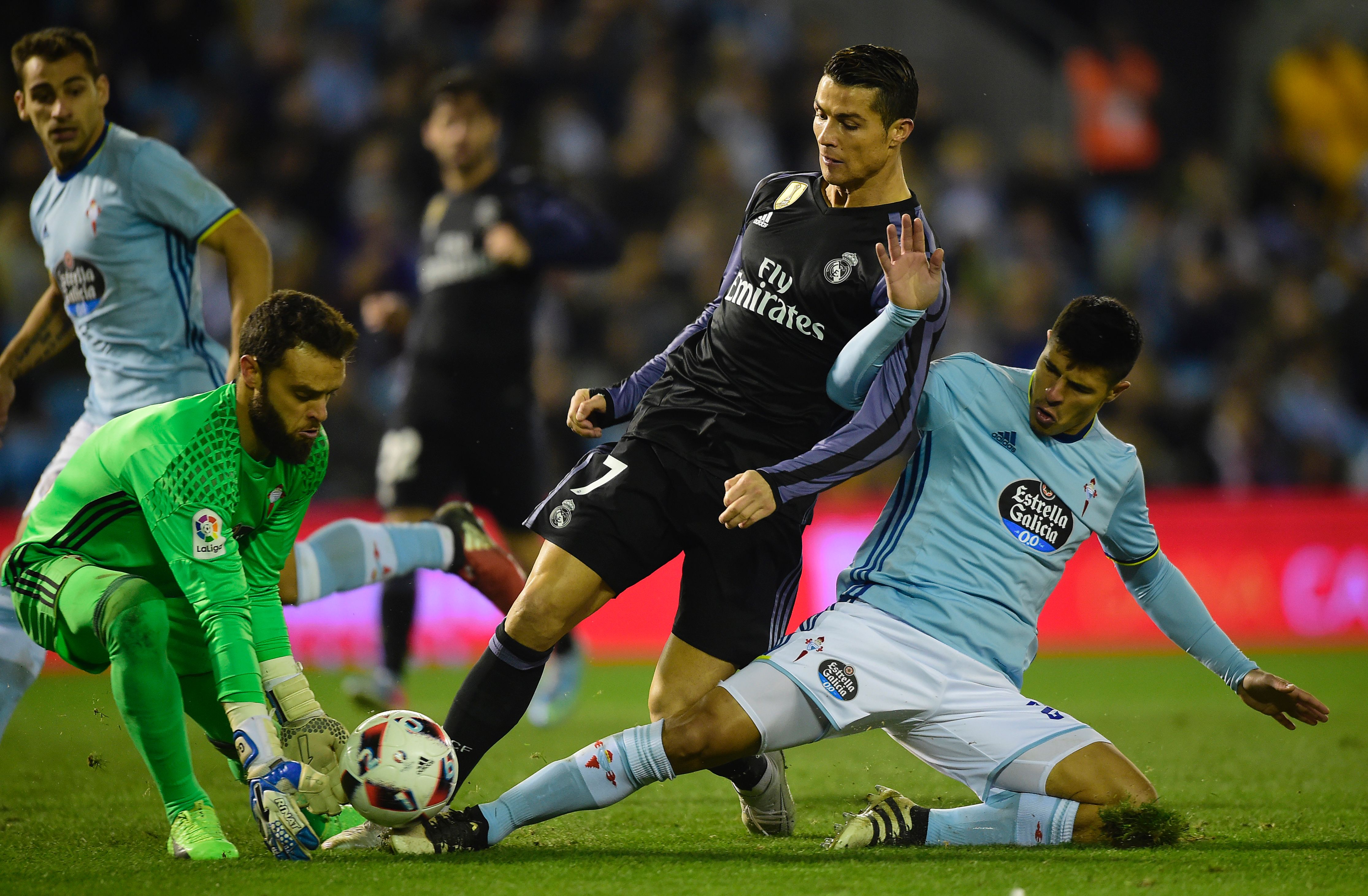 Real Madrid's Portuguese forward Cristiano Ronaldo (C) vies with Celta Vigo's goalkeeper Sergio Alvarez (L) and Celta Vigo's Argentinian defender Facundo Roncaglia during the Spanish Copa del Rey (King's Cup) quarter final second leg football match RC Celta de Vigo vs Real Madrid CF RC Celta de Vigo on January 25, 2017. / AFP / MIGUEL RIOPA (Photo credit should read MIGUEL RIOPA/AFP/Getty Images)