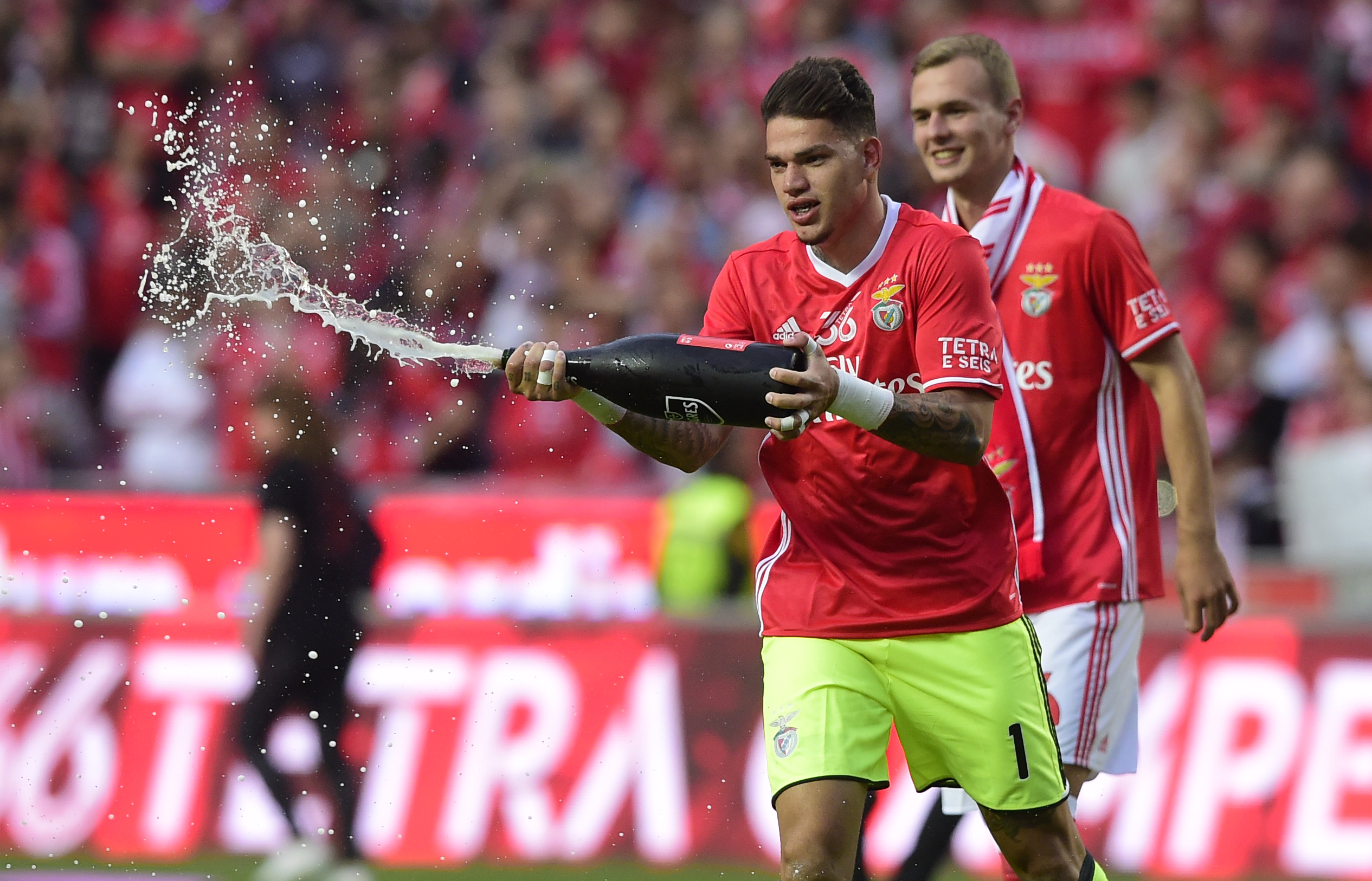 Benfica's Brazilian goalkeeper Ederson Moraes sprays champagneafter winning their 36th title at the end of the Portuguese league football match SL Benfica vs Vitoria Guimaraes SC at the Luz stadium in Lisbon on May 13, 2017.
Lisbon giants Benfica clinched a fourth straight Portuguese league title on May 13, 2017 with a 5-0 victory over Vitoria Guimaraes.
The champions have an unassailable 81 points from 33 games and cannot be caught by Porto, who are eight points behind with just two games to play. / AFP PHOTO / MIGUEL RIOPA        (Photo credit should read MIGUEL RIOPA/AFP/Getty Images)