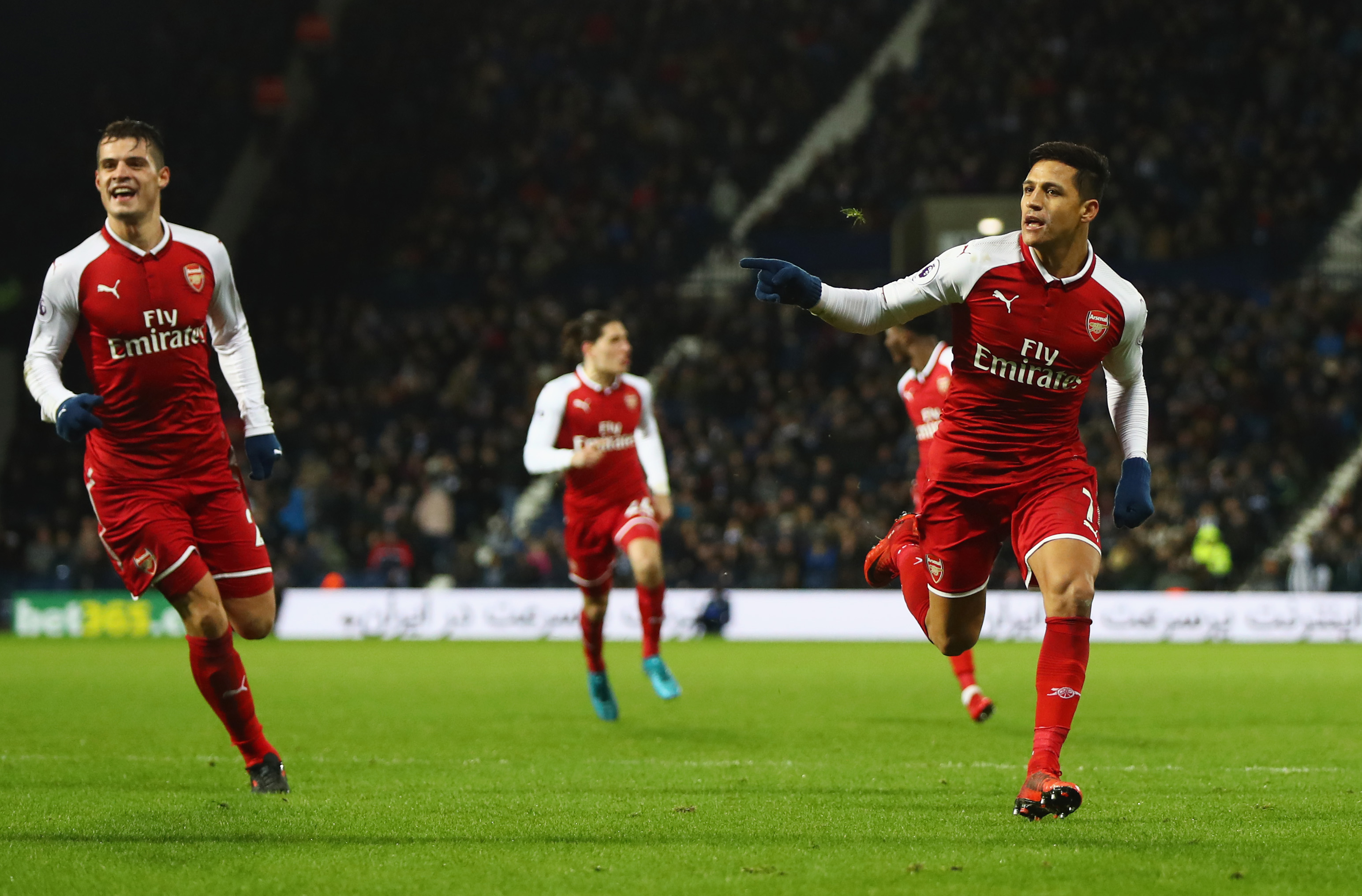 WEST BROMWICH, ENGLAND - DECEMBER 31:  Alexis Sanchez of Arsenal (R) celebrates with Granit Xhaka as his free kick deflects off James McClean of West Bromwich Albion for their first goal during the Premier League match between West Bromwich Albion and Arsenal at The Hawthorns on December 31, 2017 in West Bromwich, England.  (Photo by Michael Steele/Getty Images)