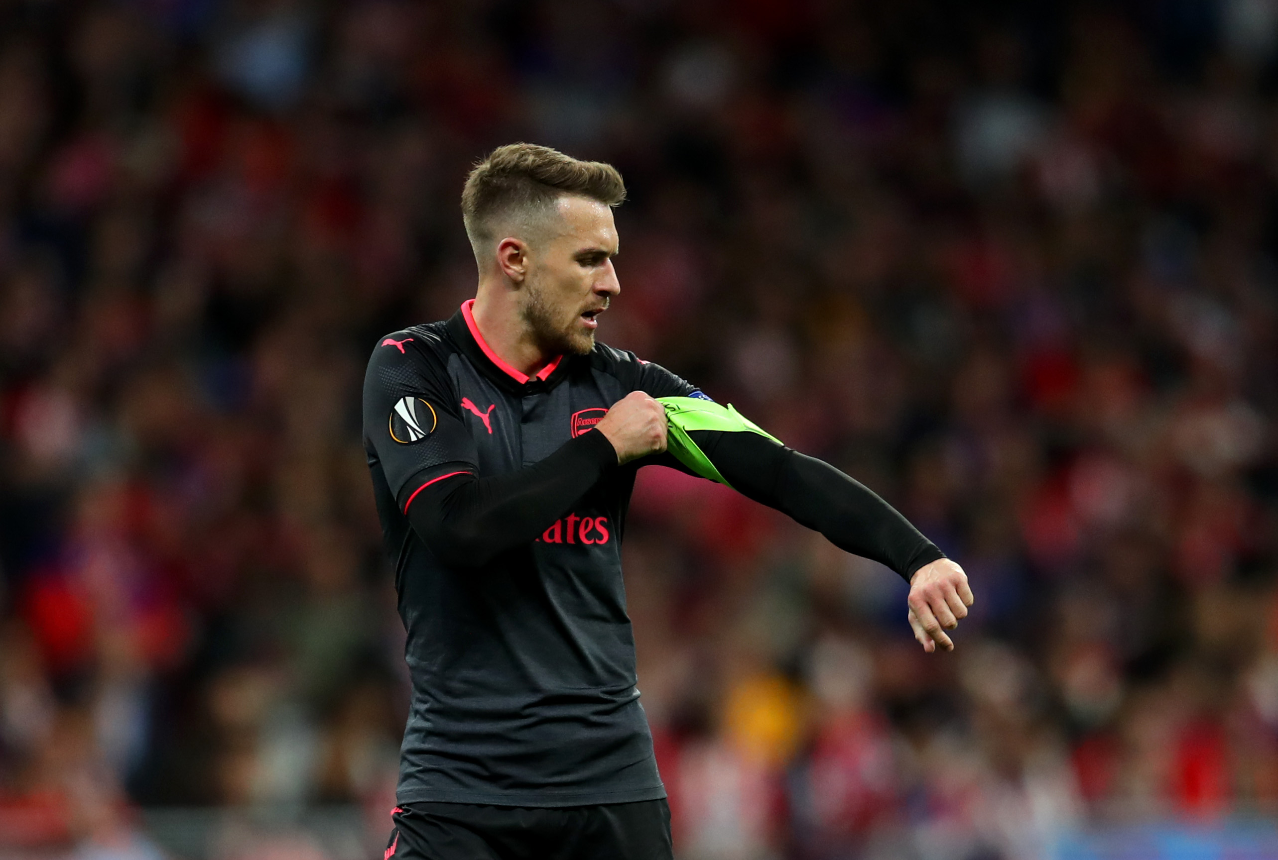 MADRID, SPAIN - MAY 03: Aaron Ramsey of Arsenal puts on the captains armband during the UEFA Europa League Semi Final second leg match between Atletico Madrid  and Arsenal FC at Estadio Wanda Metropolitano on May 3, 2018 in Madrid, Spain. (Photo by Catherine Ivill/Getty Images)