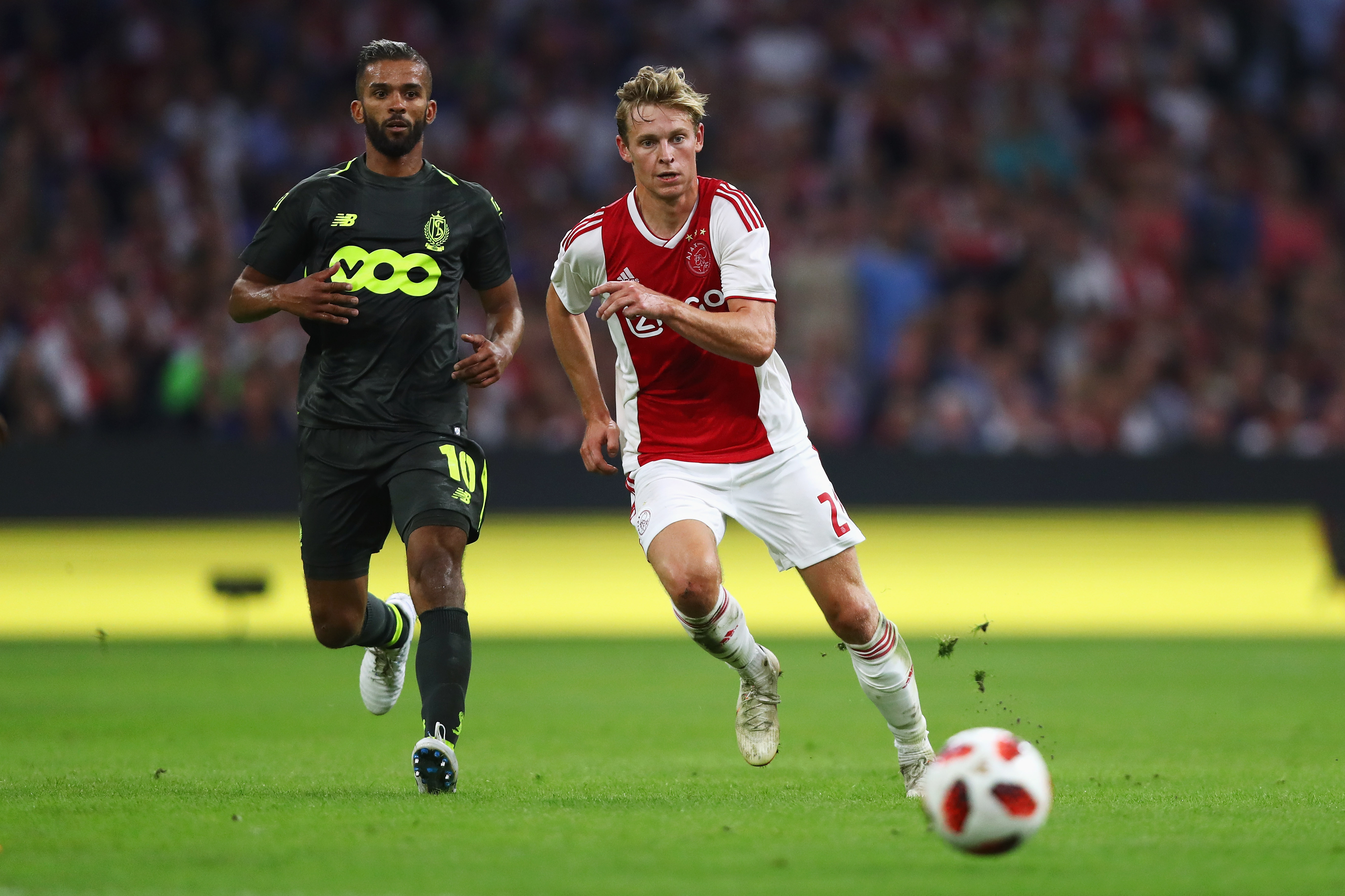 AMSTERDAM, NETHERLANDS - AUGUST 14: Frenkie de Jong of Ajax battles for the ball with Mehdi Carcela-Gonzalez of Standard de Liege during the UEFA Champions League third round qualifying match between Ajax and Royal Standard de Liege at Johan Cruyff Arena on August 14, 2018 in Amsterdam, Netherlands. (Photo by Dean Mouhtaropoulos/Getty Images)