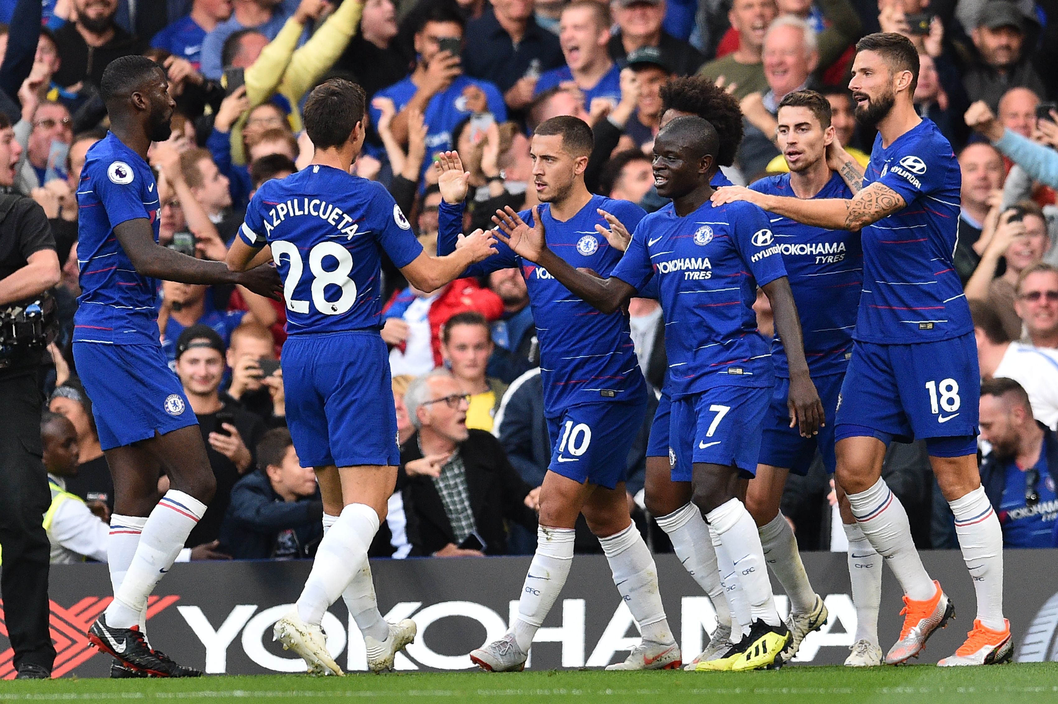 Chelsea's Belgian midfielder Eden Hazard (C) celeb rates with teammates after scoring the team's first goal during the English Premier League football match between Chelsea and Liverpool at Stamford Bridge in London on September 29, 2018. (Photo by Glyn KIRK / AFP) / RESTRICTED TO EDITORIAL USE. No use with unauthorized audio, video, data, fixture lists, club/league logos or 'live' services. Online in-match use limited to 120 images. An additional 40 images may be used in extra time. No video emulation. Social media in-match use limited to 120 images. An additional 40 images may be used in extra time. No use in betting publications, games or single club/league/player publications. / (Photo credit should read GLYN KIRK/AFP/Getty Images)