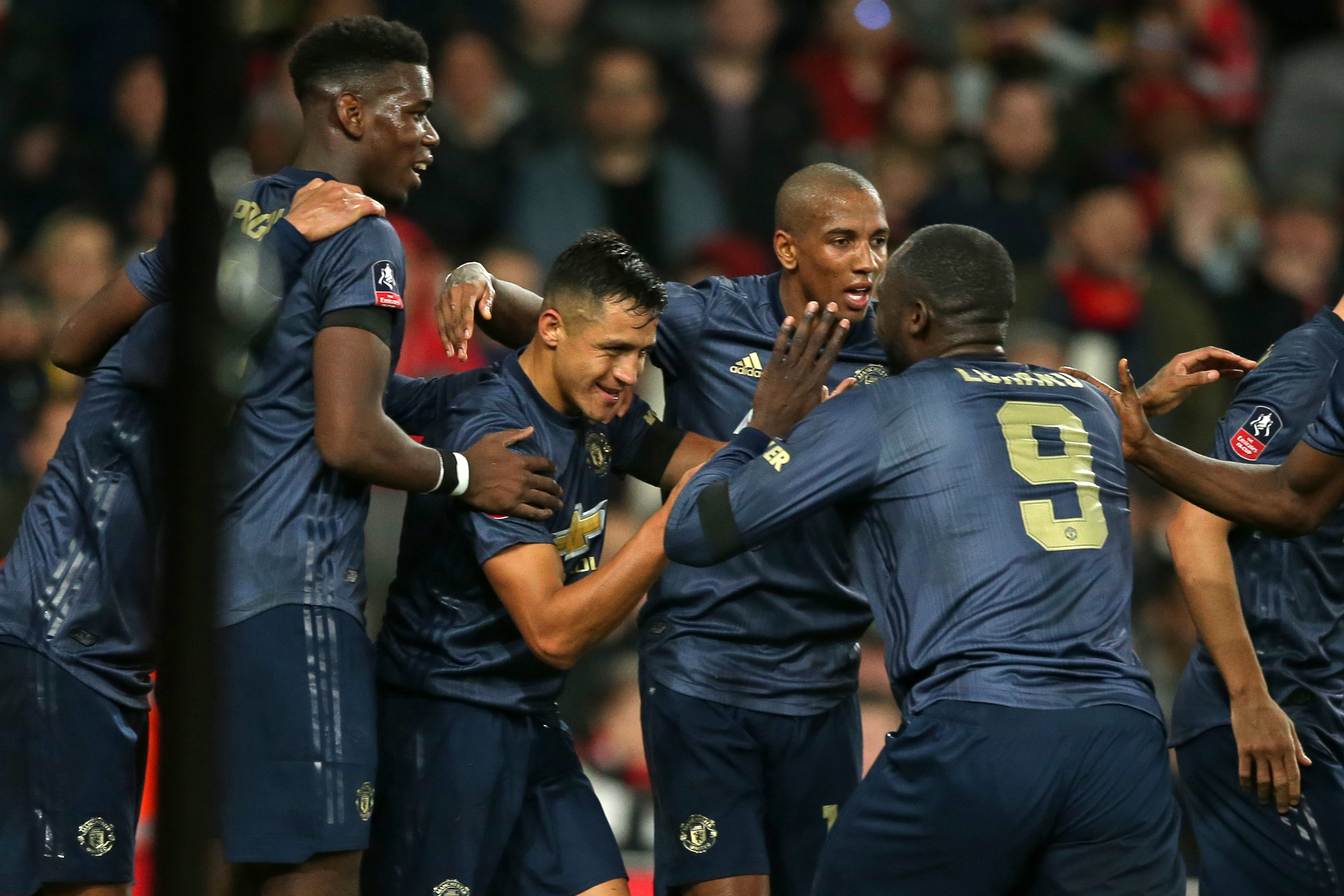 Manchester United's Chilean striker Alexis Sanchez (C) celebrates with teammates after scoring the opening goal of the English FA Cup fourth round football match between Arsenal and Manchester United at the Emirates Stadium in London on January 25, 2019. (Photo by Daniel LEAL-OLIVAS / AFP) / RESTRICTED TO EDITORIAL USE. No use with unauthorized audio, video, data, fixture lists, club/league logos or 'live' services. Online in-match use limited to 120 images. An additional 40 images may be used in extra time. No video emulation. Social media in-match use limited to 120 images. An additional 40 images may be used in extra time. No use in betting publications, games or single club/league/player publications. / (Photo credit should read DANIEL LEAL-OLIVAS/AFP/Getty Images)