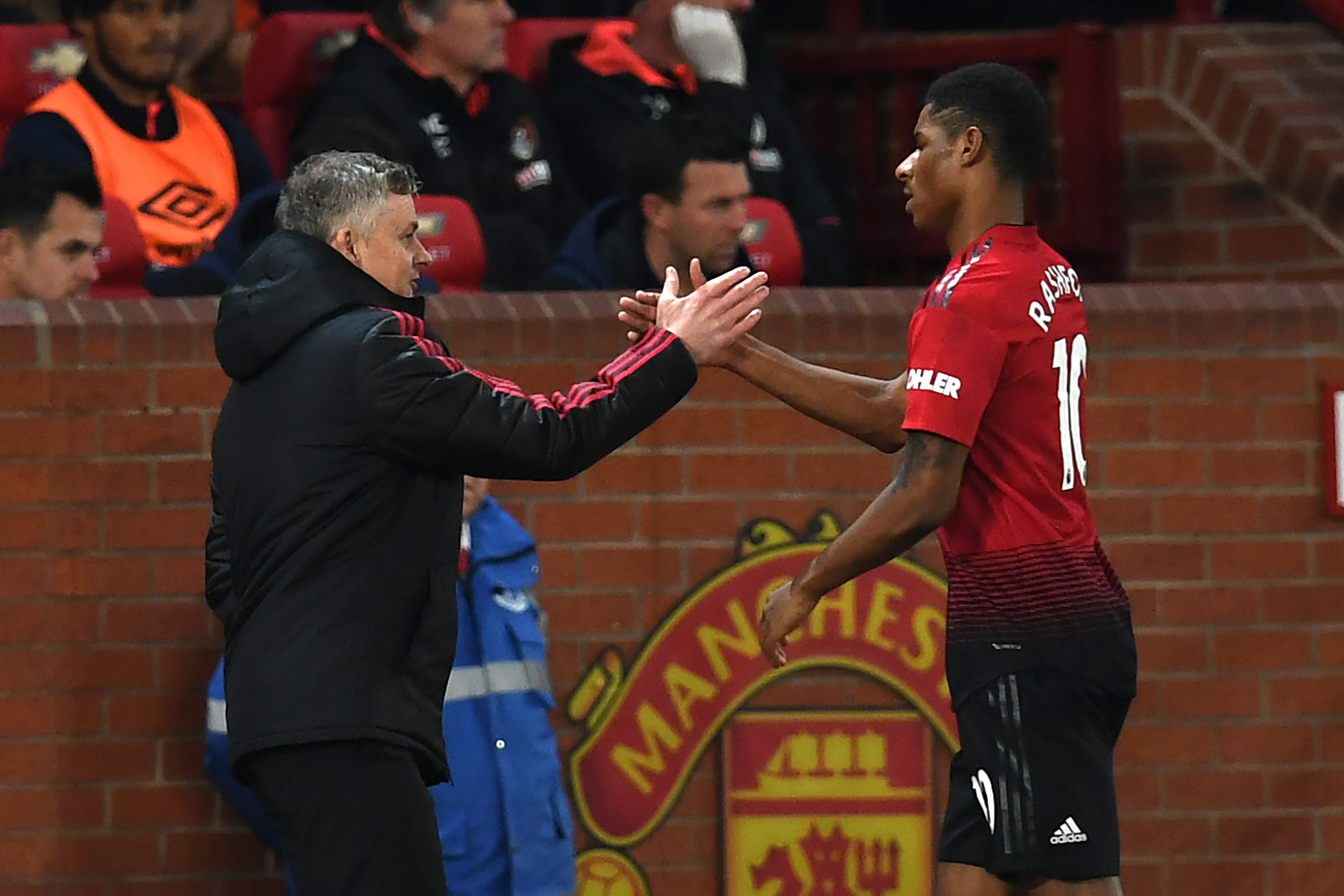 Manchester United's English striker Marcus Rashford (R) shakes hands with Manchester United's Norwegian caretaker manager Ole Gunnar Solskjaer (L) after being substituted during the English Premier League football match between Manchester United and Bournemouth at Old Trafford in Manchester, north west England, on December 30, 2018. (Photo by Paul ELLIS / AFP) / RESTRICTED TO EDITORIAL USE. No use with unauthorized audio, video, data, fixture lists, club/league logos or 'live' services. Online in-match use limited to 120 images. An additional 40 images may be used in extra time. No video emulation. Social media in-match use limited to 120 images. An additional 40 images may be used in extra time. No use in betting publications, games or single club/league/player publications. / (Photo credit should read PAUL ELLIS/AFP/Getty Images)