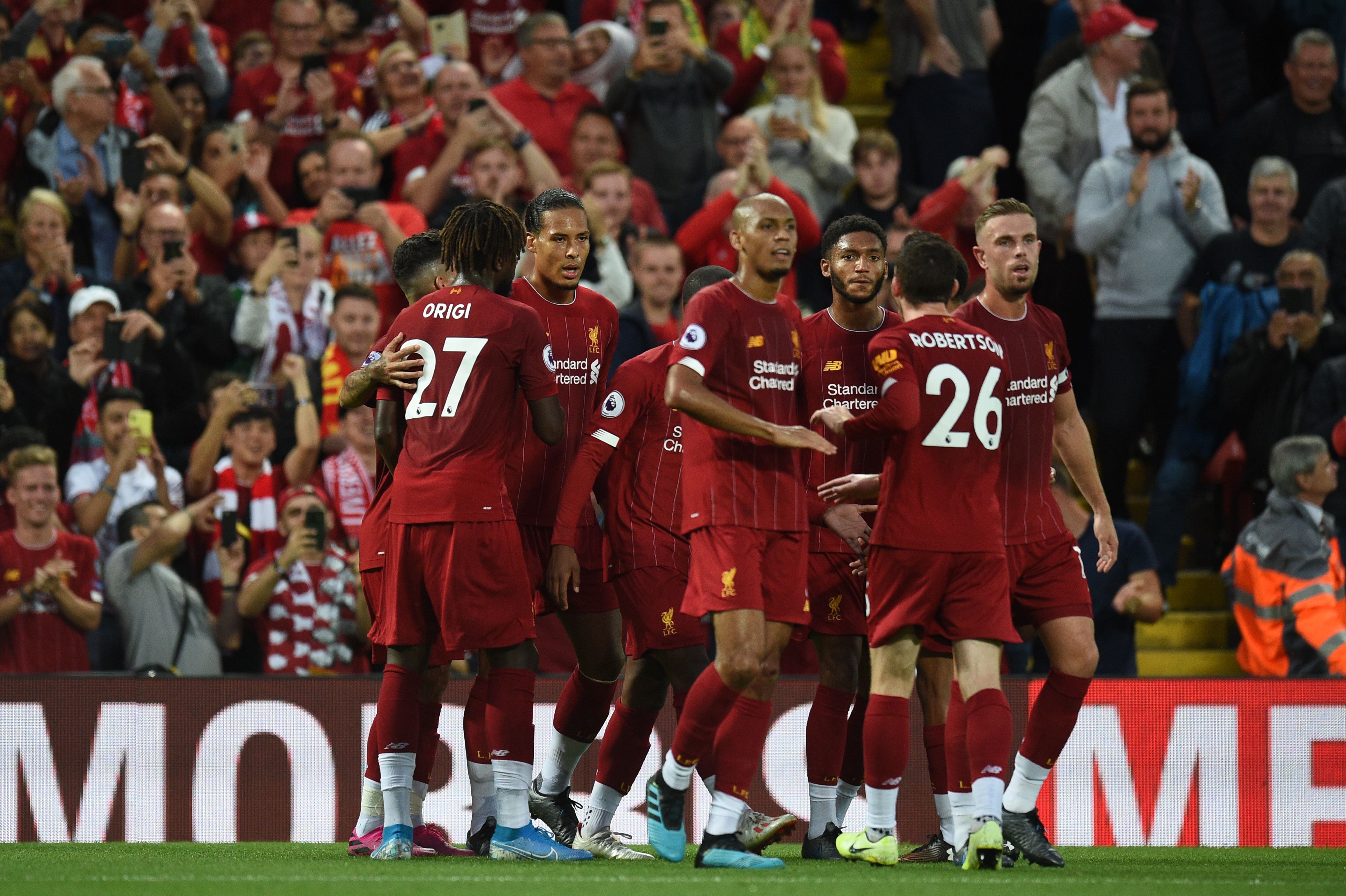 Liverpool's Dutch defender Virgil van Dijk (C)celebrates with teammates after he scores the team's third goal during the English Premier League football match between Liverpool and Norwich City at Anfield in Liverpool, north west England on August 9, 2019. (Photo by Oli SCARFF / AFP) / RESTRICTED TO EDITORIAL USE. No use with unauthorized audio, video, data, fixture lists, club/league logos or 'live' services. Online in-match use limited to 120 images. An additional 40 images may be used in extra time. No video emulation. Social media in-match use limited to 120 images. An additional 40 images may be used in extra time. No use in betting publications, games or single club/league/player publications. / (Photo credit should read OLI SCARFF/AFP/Getty Images)